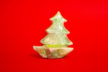 Small decorative green Christmas tree on a red background