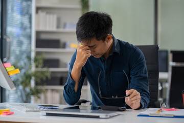 stressed asian businessman working in the office. Businessman thinking too much work concept in the office.