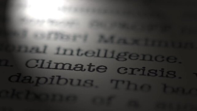 Climate crisis. Moving text printed on a page. Slow motion. A piece of paper with a phrase written in retro typewriter font. Spotlight effect. Dramatic video.
