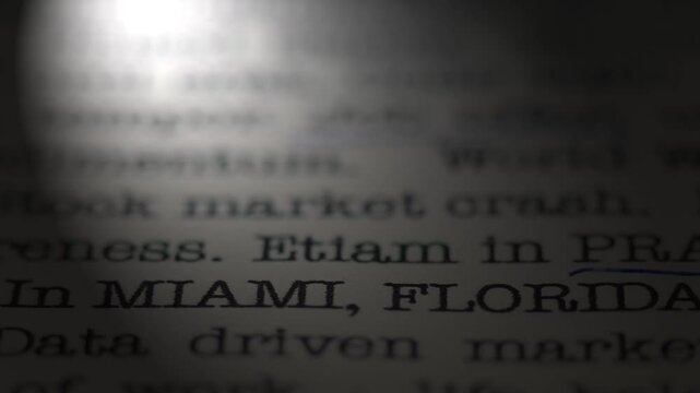 Miami, Florida, United States. Moving text printed on a page. Place of interest. A piece of paper with a phrase written in retro typewriter font. Spotlight effect. Dramatic video.