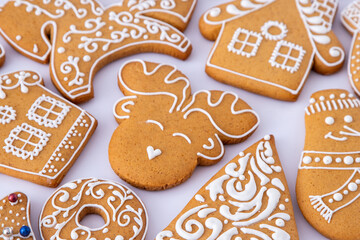 Gingerbread decorated with white sugar glaze. Food background. Christmas tree cookies. Reindeer shape