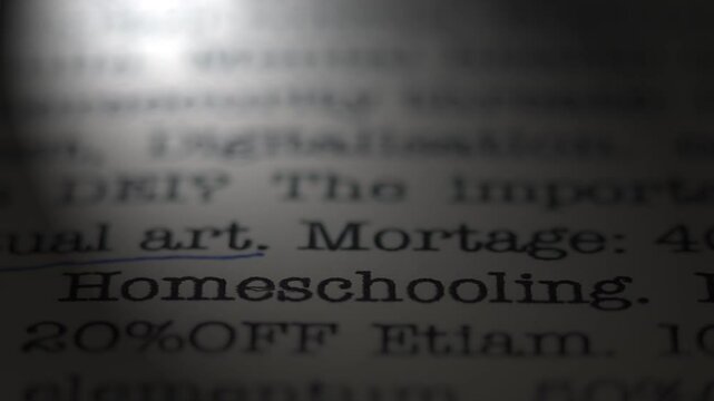 The topic of homeschooling. Moving text printed on a page. Headline. A piece of paper with a phrase written in retro typewriter font. Spotlight effect. Dramatic video.