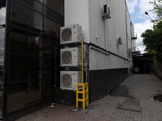 A couple of air conditioners sitting on top of a metal rack