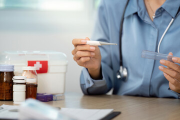 Health Checkup. Nurse holding thermometer and medication in clinical setting.