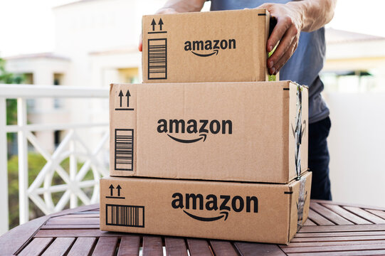 DUBAI, UAE - April 27, 2023. Amazon Prime delivery package cardboard of the Middle East in United Arab Emirates paper box male fast courier service
