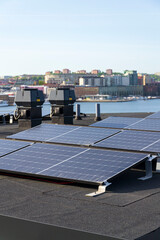 Solar panels on roof of apartment housing building with Gothenburg city center in background, Sweden, renewable green sustainable energy concept