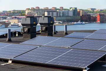 Solar panels on roof of apartment housing building with Gothenburg city center in background, Sweden, renewable green sustainable energy concept