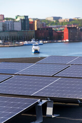 Solar panels on roof of apartment housing building with Gothenburg city center in background, Sweden, renewable green sustainable energy concept