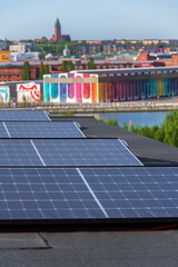 Solar panels on roof of apartment housing building with Gothenburg city center in background, Sweden, renewable green sustainable energy concept