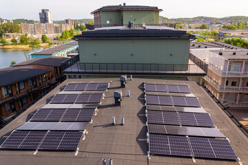 Solar panels on roof of apartment housing building with Gothenburg city center in background, Sweden, renewable green sustainable energy concept