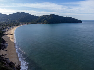Fototapeta premium Beautiful coastal village with beautiful green water beach and tropical mountains around