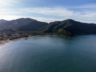 Obraz premium Beautiful coastal village with beautiful green water beach and tropical mountains around