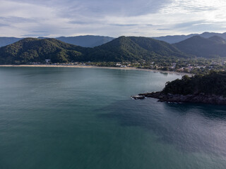 Obraz premium Beautiful coastal village with beautiful green water beach and tropical mountains around