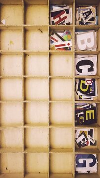 alphabet with magazine letters in a wooden box 