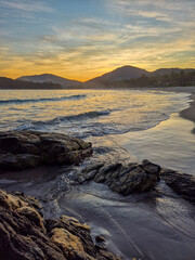 amazing red sunset among the rocks on a tropical beach