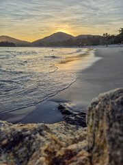 amazing red sunset among the rocks on a tropical beach