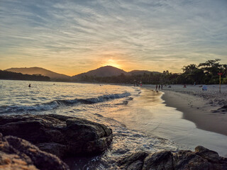 amazing red sunset among the rocks on a tropical beach
