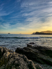 amazing red sunset among the rocks on a tropical beach