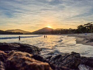 amazing red sunset among the rocks on a tropical beach