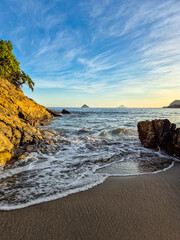amazing red sunset among the rocks on a tropical beach