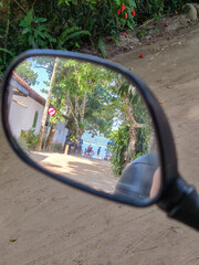 beach village through motorcycle rear view mirror