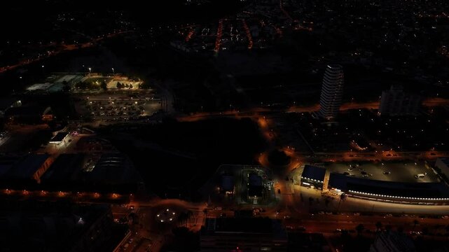 Drone glides over Estimar Hotel in Calpe at night, with glowing windows, pool lights, and the coastline illuminated under a starry sky.
