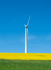 countryside landscape in luxemburg with wind turbine under blue sky in spring
