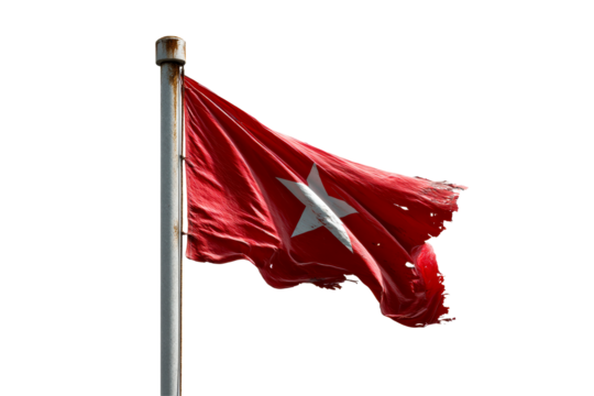 A torn red flag featuring a white star flutters on a pole
