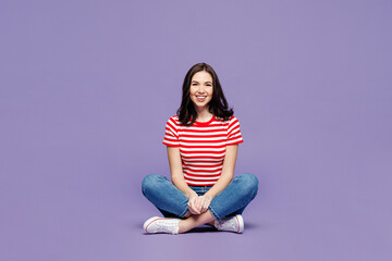 Full body young smiling happy cool Caucasian woman she wear red striped t-shirt casual clothes sit looking camera isolated on plain pastel light purple background studio portrait. Lifestyle concept. © ViDi Studio