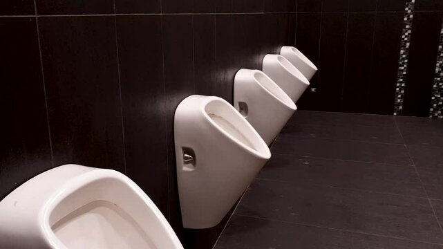 Row of outdoor urinals for the men's public restroom. Men's urinals. Public men's toilets.