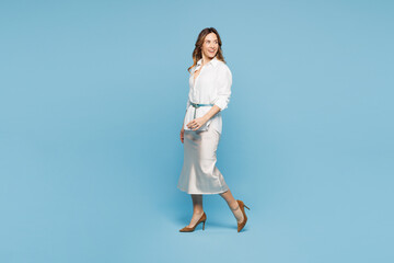 Full body sideways young happy employee business woman corporate lawyer wears shirt classic formal clothes work in office walk go look aside isolated on plain pastel blue background studio portrait.