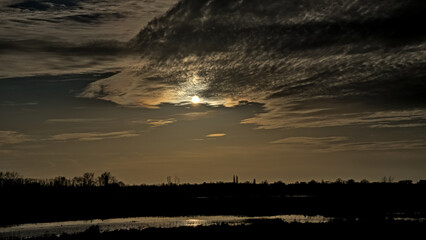Cloudy sky with evening sun and grey clouds over Bourgoyen nature reserve, Ghent, Flanders, Belgium 