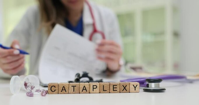 Medical doctor analyzes patient documents with Cataplexy shown on cubes diagnosis. Treatment options with pills and stethoscope on table in hospital