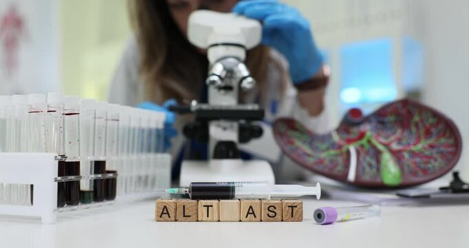 Scientist uses microscope to analyze blood samples and to study ALT AST diagnosis. Overreaction of immune system to normally harmless substances