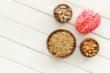 Healthy food for the brain. Human brain model with nuts and grain, top view