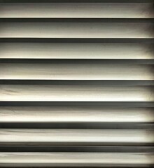 Close-up of horizontal closed blinds creating light and shadow.