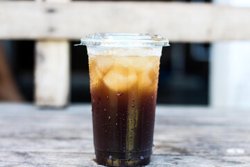 Iced Black Coffee in Clear Cup on Wooden Table.