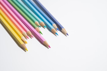 Colored pencils with colored shavings on a white background