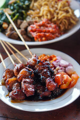 Assorted Satay, Indonesia, captured on May 29, 2025. A traditional Indonesian dish featuring skewered and grilled meat varieties served with spicy peanut sauce, soy glaze, and fresh side dishes