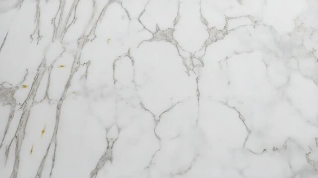 A close up view of a white marble surface with subtle gray veins and natural stone patterns shown background texture video