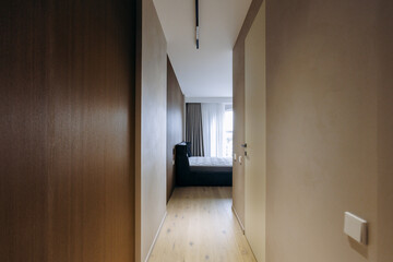A long hallway that leads to a spacious bedroom featuring a bed