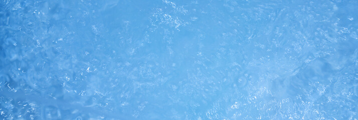 Blue water with ripples. Defocus blurred bleu clear calm water surface texture with splashes and bubbles.