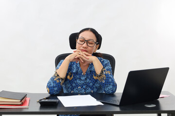 Portrait of tired young woman sleeping on her desk in the office
