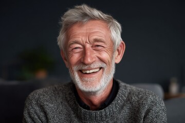 Happy elderly man with gray hair smiling at the camera, looking content and enjoying life.