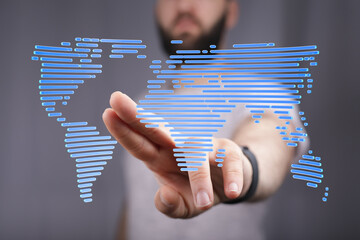 Abstract image of a hand interacting with a digital world map, symbolizing global connectivity and...
