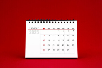 October 2025 Blank desk calendar on red background.