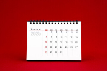 December 2025 Blank desk calendar on red background.