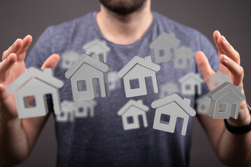 Image of a man showcasing numerous house icons, symbolizing real estate investment opportunities.