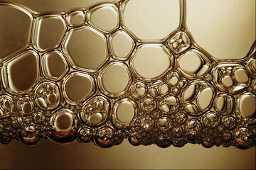 Close-up macro of golden soap bubbles forming intricate patterns—perfect for artistic, poetic,...