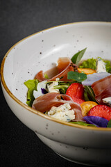 Salad mix with jamon, baby mozzarella, strawberries and vinaigrette sauce.